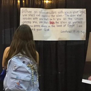 A youth reading signs in the Hall of Welcome.