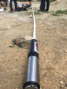 The electric pump attached to 130 ft of pipe ready to be put in the well.