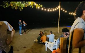 People sitting and dancing on the beach